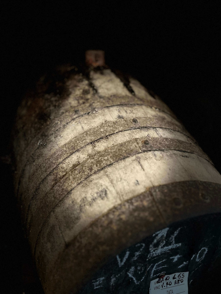 Gros plan sur la texture usée d'un ancien foudre en châtaignier utilisé pour l'élevage traditionnel de la Vernaccia di Oristano sous voile.