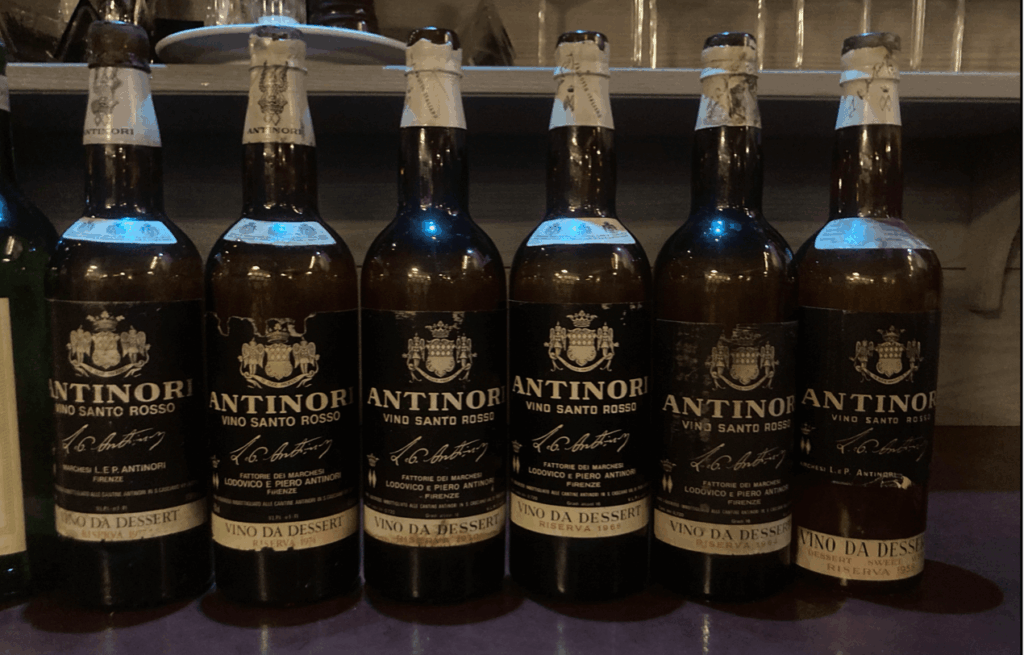 Alignement de six bouteilles anciennes de Vin Santo Rosso Antinori, millésimes 1958 à 1977, présentées pour une dégustation verticale exceptionnelle.